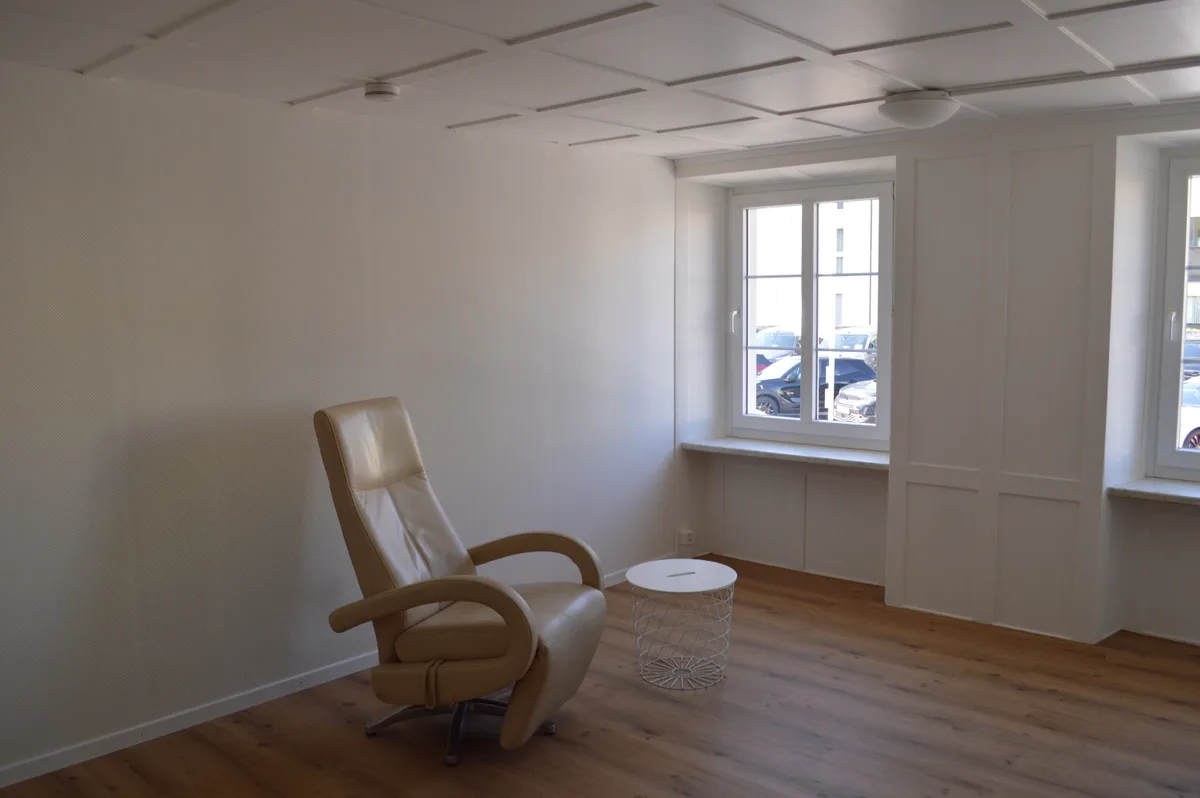 Ein Altbau-Zimmer mit einem Sessel.